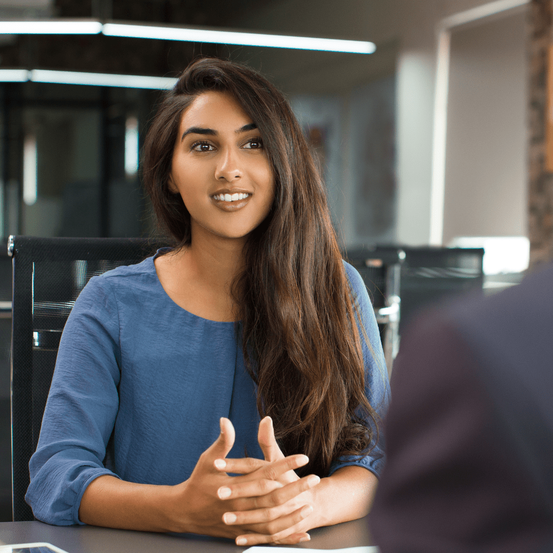 An immigrant woman sits at a job interview.